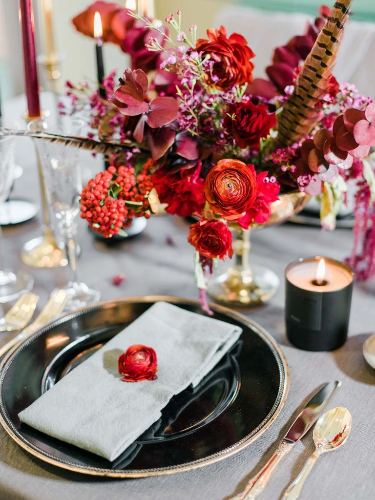 A gothic-romantic tablescape with black taper candles and dark florals.