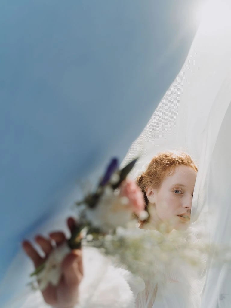 A wedding photographer in the field with a 35mm film camera at golden hour.