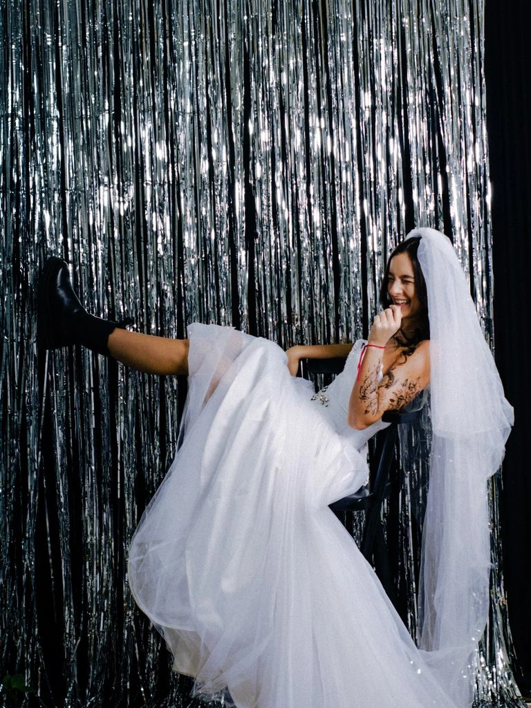 A bride in a black structured gown in a sunlit doorway.
